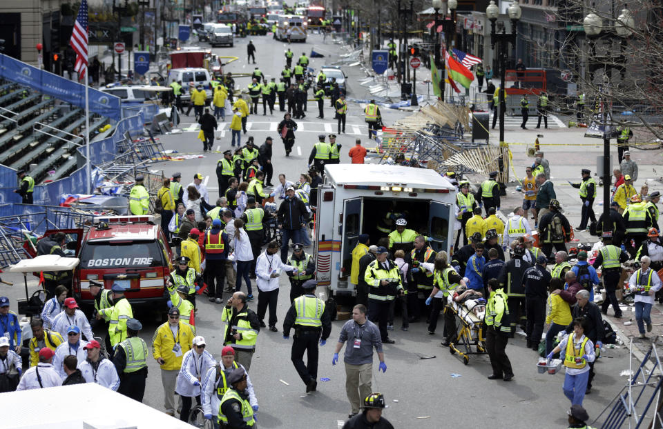 FILE - In this April 15, 2013 file photo, medical workers aid injured people near the finish line of the 2013 Boston Marathon following two bomb explosions in Boston. In the course of a year, limbs have been replaced, psyches soothed, the wounds sustained in a moment at the marathon’s finish line have at least begun to heal. At the same time, a city shaken by an act of terrorism has returned to its usual rhythms - sadder, but some say stronger, as well. (AP Photo/Charles Krupa, File)