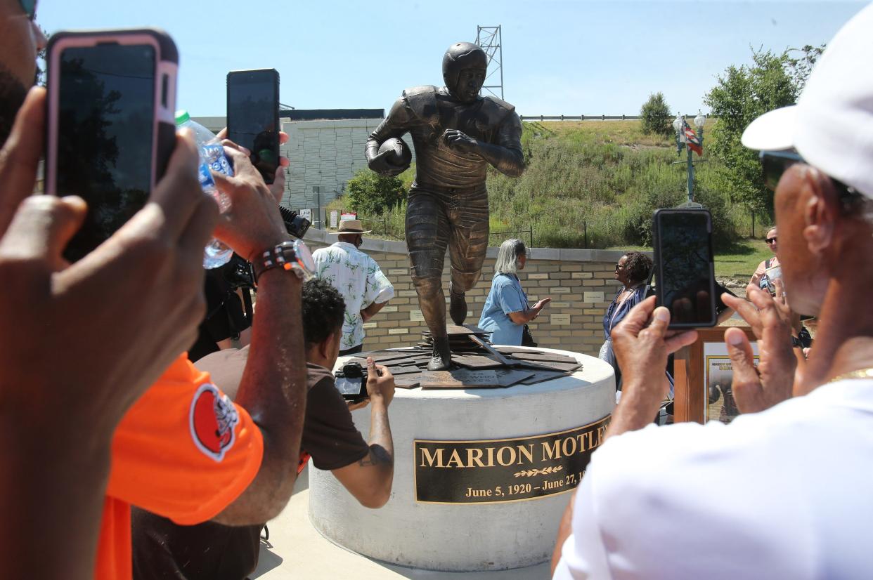 People take photos of the Marion Motley statue after it was unveiled in Canton on Wednesday, Aug. 3, 2022.