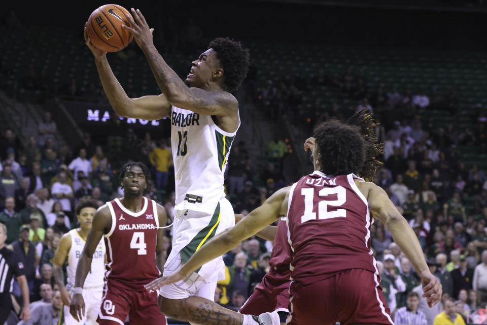 Baylor guard Langston Love (13) shoots against Oklahoma guard Milos Uzan (12) and guard Joe Bamisile (4) during the second half of an NCAA college basketball game Wednesday, Feb. 8, 2023, in Waco, Texas. (AP Photo/Rod Aydelotte)