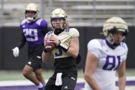 Washington quarterback Jacob Sirmon, center, drops to pass during NCAA college football practice, Friday, Oct. 16, 2020, in Seattle. (AP Photo/Ted S. Warren)