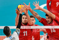 <p>France's Antoine Brizard (C) and France's Nicolas le Goff (R) block a shot in the men's preliminary round pool B volleyball match between Argentina and France during the Tokyo 2020 Olympic Games at Ariake Arena in Tokyo on July 28, 2021. (Photo by ANDREJ ISAKOVIC / AFP)</p> 