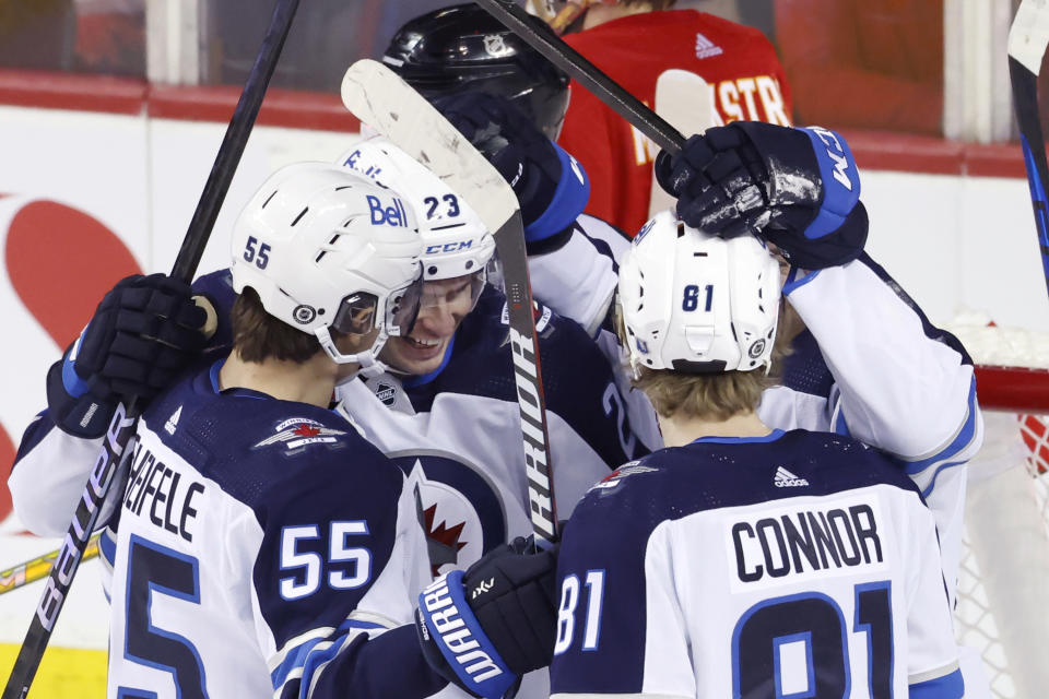 Winnipeg Jets' Sean Monahan celebrates with teammates during the first period of an NHL hockey game in Calgary, Alberta, Monday, Feb. 19, 2024. (Larry MacDougal/The Canadian Press via AP)