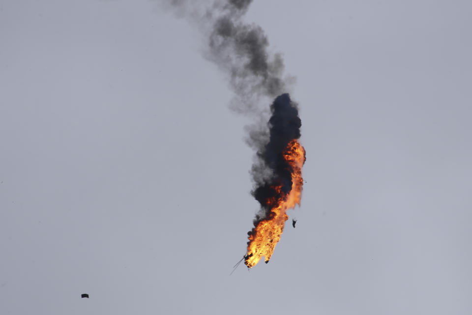 Syrian government helicopter bursts in flames after it was shot by a missile in Idlib province, Syria, Tuesday, Feb. 11, 2020. Syrian rebels shot down a government helicopter Tuesday in the country's northwest where Syrian troops are on the offensive in the last rebel stronghold. (AP Photo/Ghaith Alsayed)
