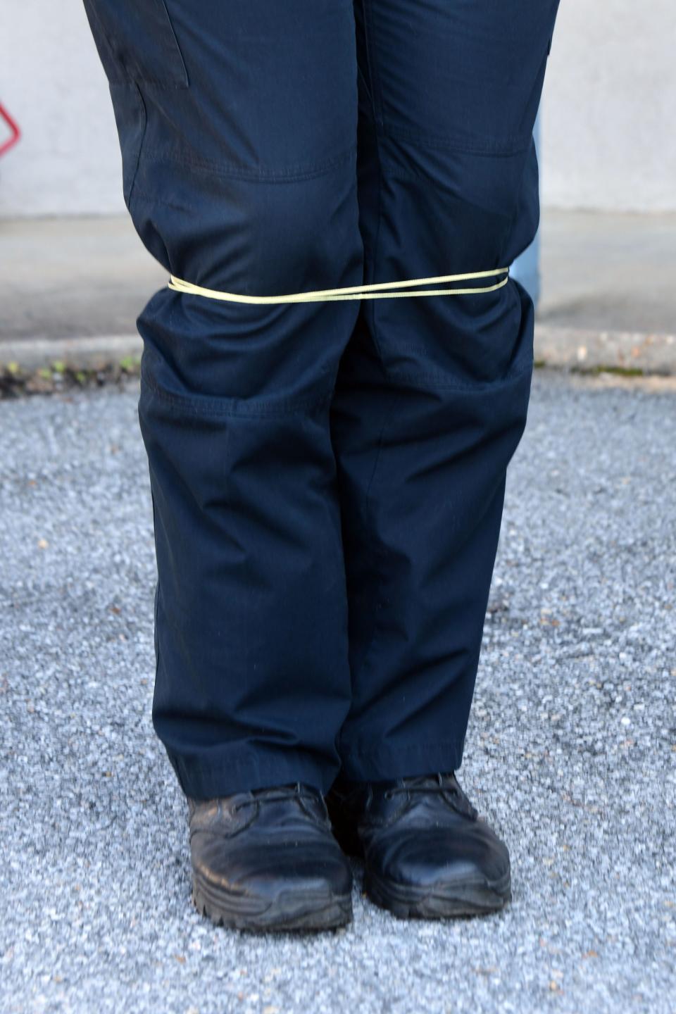 The legs of DeFuniak Springs Police Officer Josh McKee are immobilized during a demonstration of the BolaWrap restraint system. The Police Department is training officers to deploy the new tool, which can restrain a person without causing serious injury.