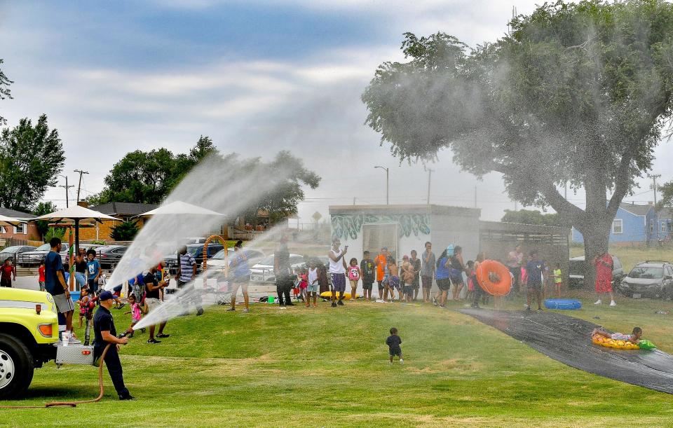 The Amarillo Fire Department adds water for the slip and slide at the Second Annual Unity in the Community Water Bash at Bones Hooks Park in this file photo. This year's bash is Saturday.