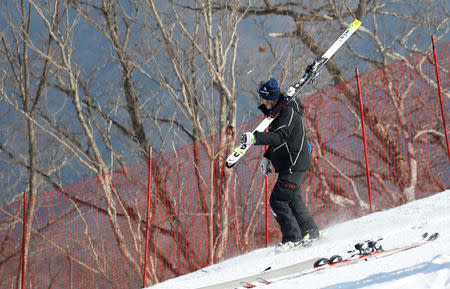 Heinz Haemmerle, or "Magic Heinzi" as US skier Lindsey Vonn calls her Austrian-born ski technician, skis down with an unused pair of skis of the world's most successful skiing woman after Vonn left the starting house for her third Olympic Downhill training run at the Winter Olympics 2018 in Pyeongchang, South Korea, February 20, 2018. REUTERS/Leonhard Foeger