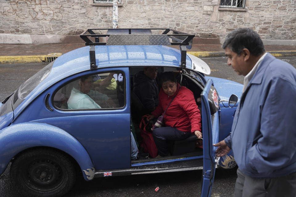 El taxista Rafael Ortega ayuda a los pasajeros a entrar en un Beetle de Volkswagen en el vecindario de Cuautepec en Ciudad de México, el viernes 21 de junio de 2024. El vecindario norteño tiene tantos Beetles, o "vochos", que se ha ganado el apodo de "Vocholandia". (AP Foto/Aurea Del Rosario)