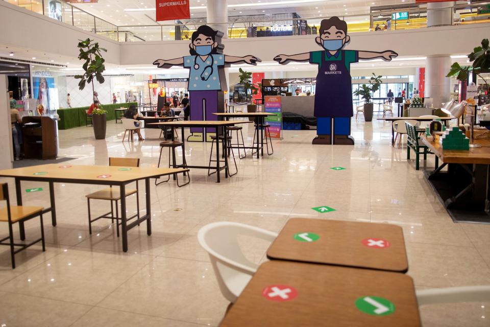 Billboards of characters wearing masks and maintaining social distancing are placed in the middle of a shopping mall where extra dining tables are placed to maintain social distancing in restaurants, as the Philippine government allows dining-in following months of restrictions due to the coronavirus disease (COVID-19) outbreak, in Mandaluyong City, Metro Manila, Philippines, June 16, 2020. REUTERS/Eloisa Lopez