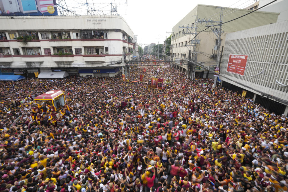 A glass-covered cart carrying the Black Nazarene makes its way through the crowd during its annual procession which was resumed after a three-year suspension due to the coronavirus pandemic on Tuesday, Jan. 9, 2024 in Manila, Philippines. A mammoth crowd of mostly barefoot Catholic devotees joined a chaotic procession through downtown Manila Tuesday to venerate a centuries-old black statue of Jesus Christ with many praying for peace in the Middle East where Filipino relatives work. (AP Photo/Aaron Favila)