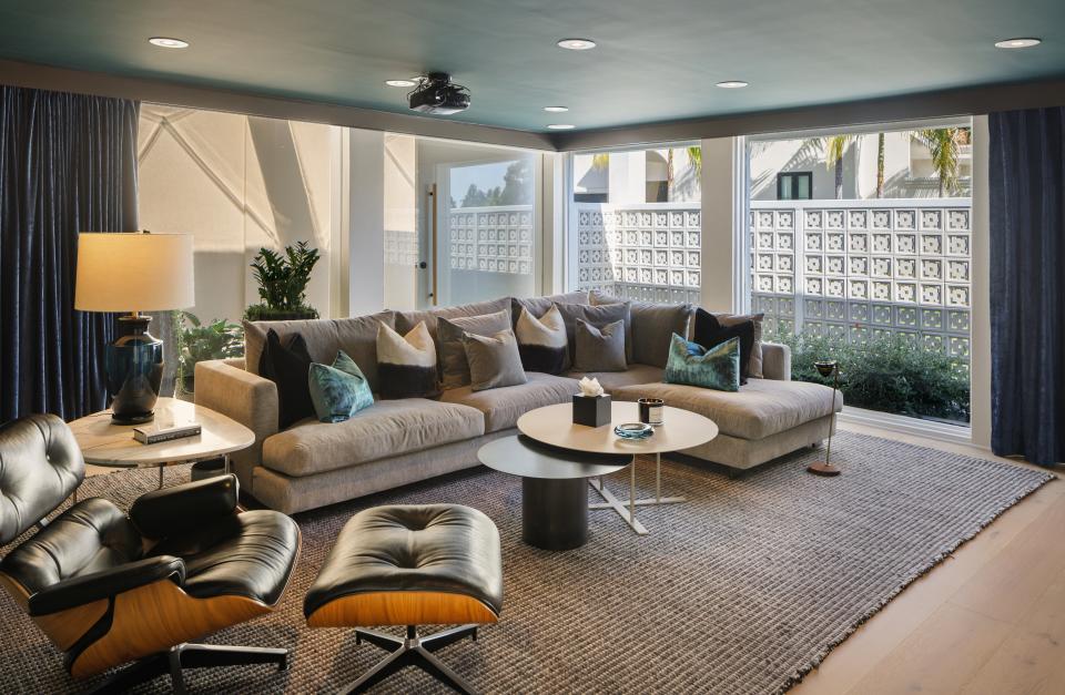 A lounge area inside the home offers lots of natural light via glass walls.
