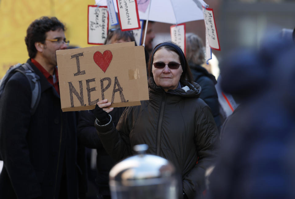 Joan Lutz of Boulder, Colo., waves a placard at a rally of advocates to voice opposition to efforts by the Trump administration to weaken the National Environmental Policy Act, which is the country's basic charter for protection of the outdoors on Tuesday, Feb. 11, 2020, in Denver. (AP Photo/David Zalubowski)