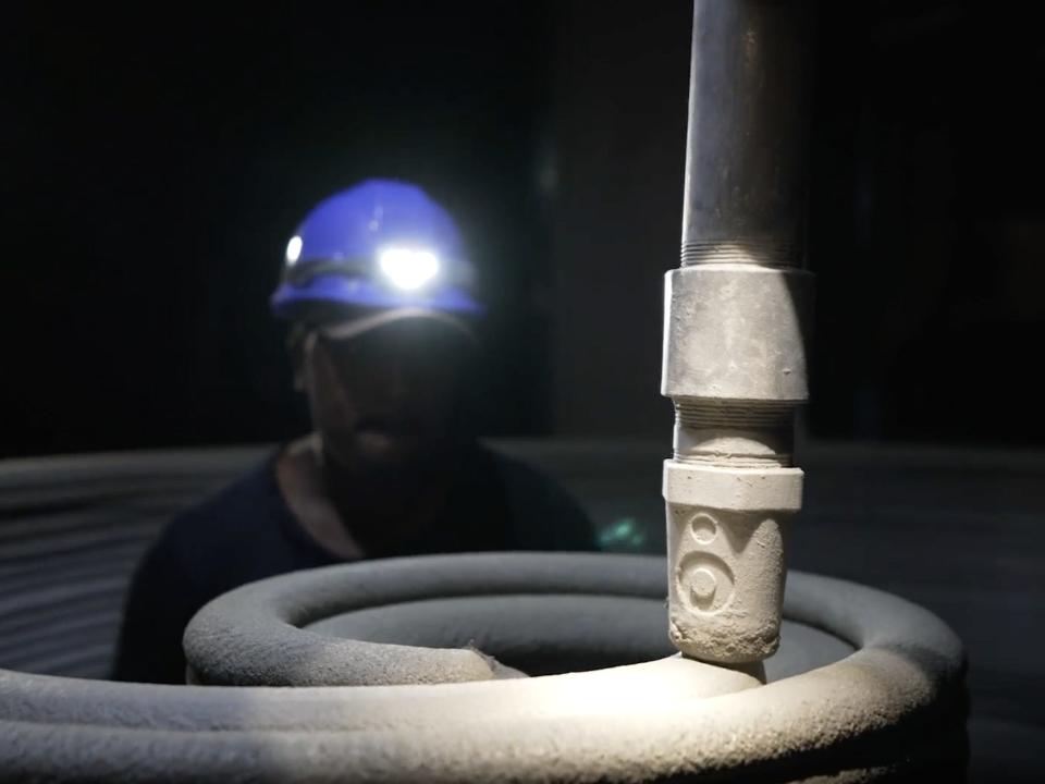 A person monitoring Icon's 3D printer at night as it prints out "lavacrete."