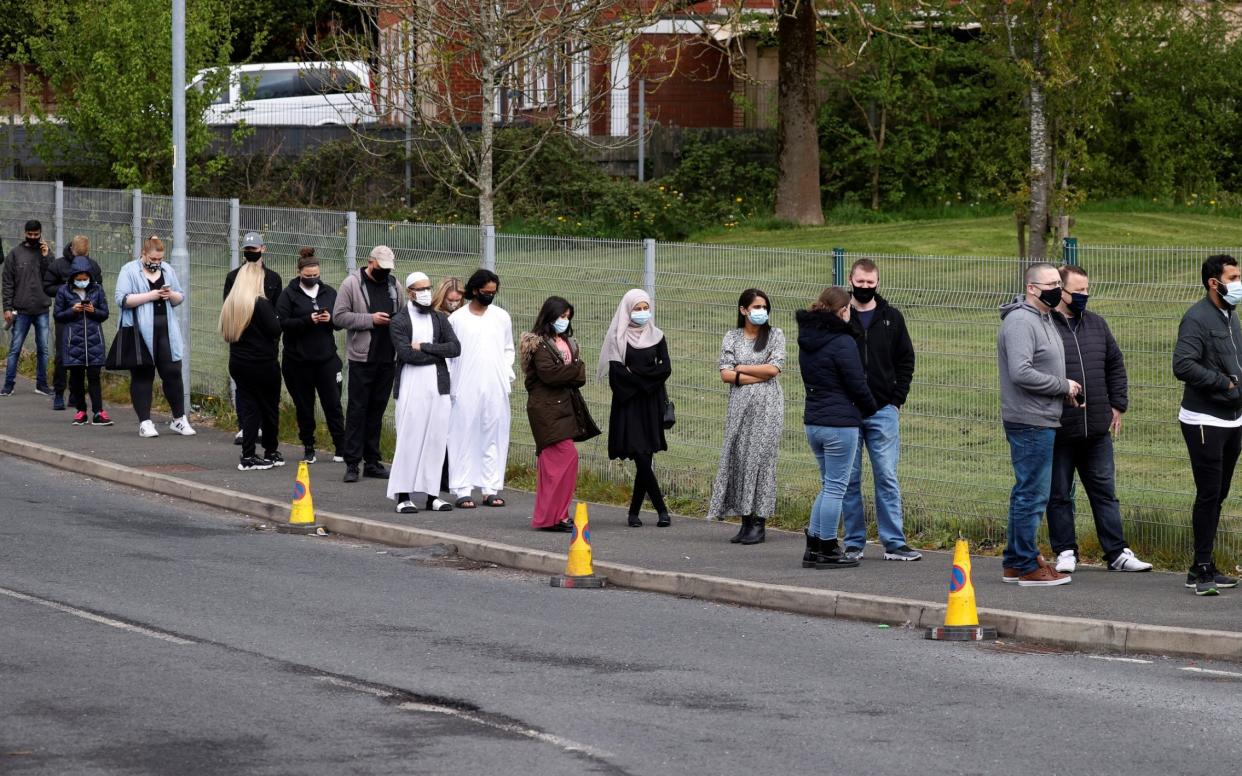 People line up outside a mobile vaccination centre in Bolton - Phil Noble/Reuters