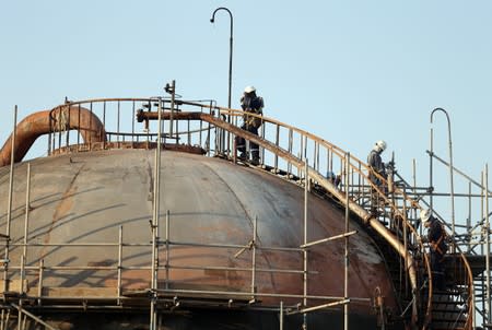 Workers are seen at the damaged site of Saudi Aramco oil facility in Abqaiq