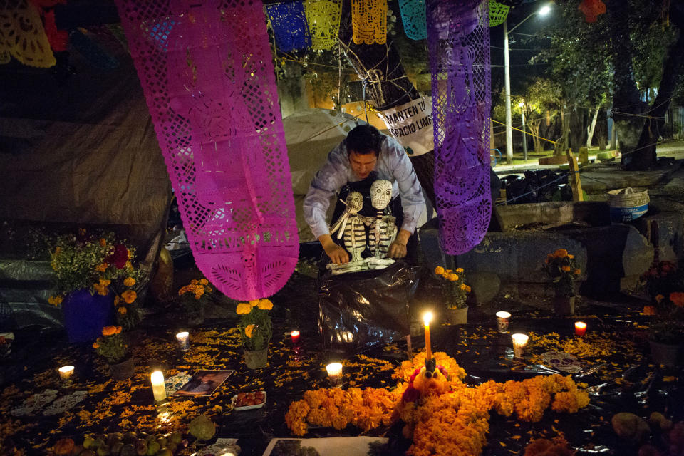 <p>A young man arranges skeletons on a Day of the Dead altar at a tent encampment at Multifamiliar Tlalpan, where nine people died when a building collapsed in the Sept. earthquake, in Mexico City, Tuesday, Oct. 31, 2017. People in Mexico are marking this yearâs holiday by remembering the people killed in the Sept. 19 earthquake. (Photo: Rebecca Blackwell/AP) </p>