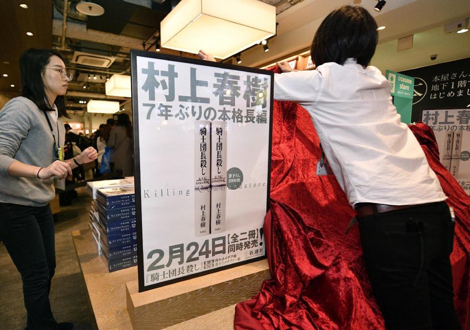 In this Thursday, Feb. 23, 2017, photo, workers prepare a display before the start of the sale of Haruki Mrakami's new book in Osaka, western Japan. Murakami's new book "Kishidancho Goroshi," or "Killing Commendatore," is a two-part story about a 36-year-old portrait painter and the mysterious incidents that happen after his wife divorces him and he moves into an old house on a mountainside west of Tokyo. The sign reads "Haruki Murakami. Full-scale long story in seven years." (Tsuyoshi Ueda/Kyodo News via AP)