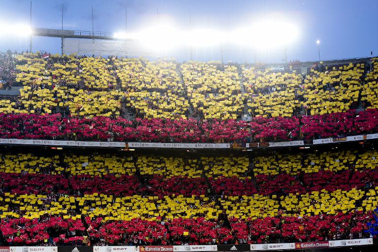 Football fans hold flags with FC Barcelona's colours prior to the Spanish Copa del Rey (King's Cup) final football match Athletic Club Bilbao vs FC Barcelona at the Camp Nou stadium in Barcelona on May 30, 2015