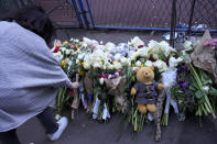 People lay flowers for the victims near the Vladislav Ribnikar school in Belgrade, Serbia, Wednesday, May 3, 2023. Police say a 13-year-old who opened fire at his school drew sketches of classrooms and made a list of people he intended to target. He killed eight fellow students and a school guard before being arrested. (AP Photo/Darko Vojinovic)