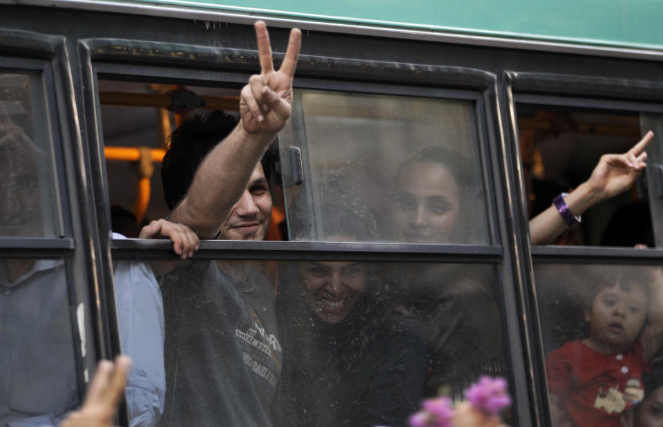 Passengers in a public bus flash victory signs in a reaction of supporters of the Iranian presidential candidate Hassan Rouhani, as they attend a celebration gathering, in Tehran, Iran, Saturday, June 15, 2013. (AP Photo/Vahid Salemi)