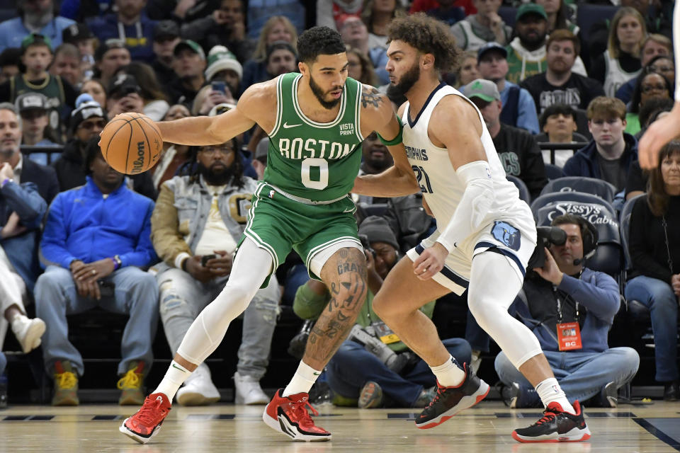 Boston Celtics forward Jayson Tatum (0) handles the ball against Memphis Grizzlies forward David Roddy (21) in the first half of an NBA basketball game Sunday, Nov. 19, 2023, in Memphis, Tenn. (AP Photo/Brandon Dill)