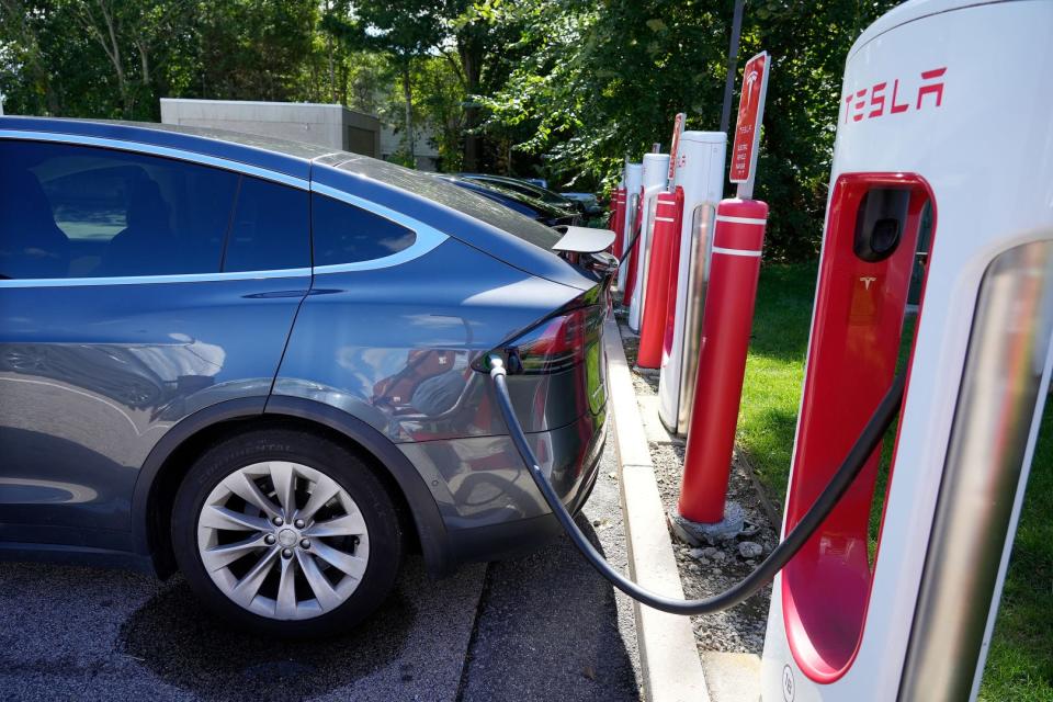 Rachel Hodgdon of New York City charges her car at the Tesla super-charging station at Dave's Marketplace on Division Street in East Greenwich.