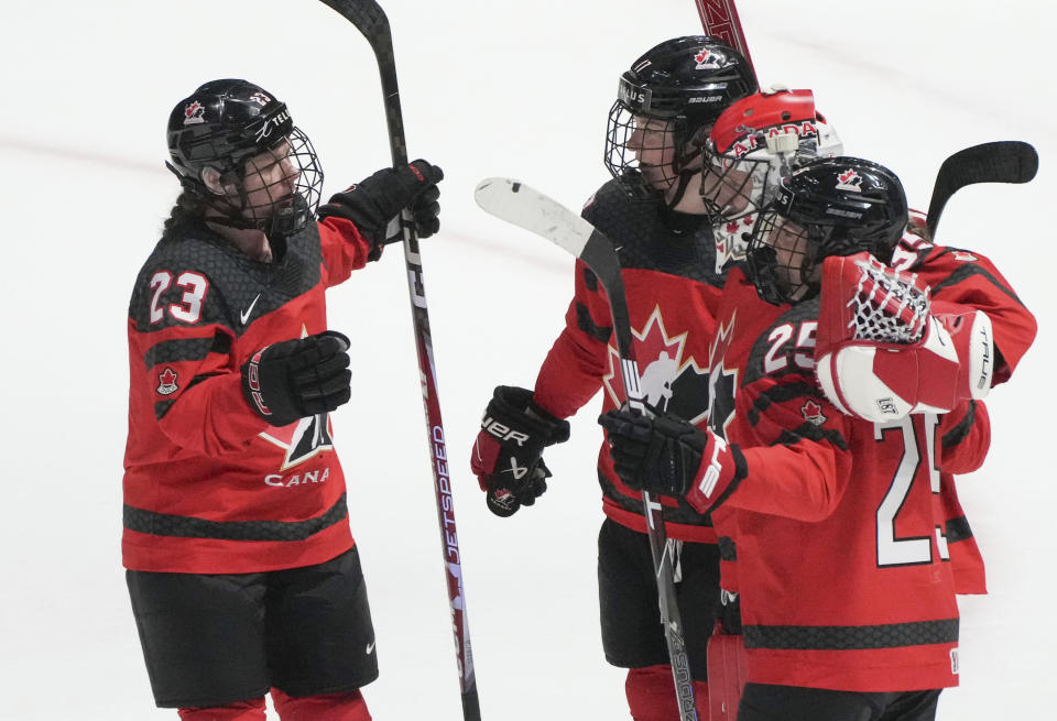 Canada's Erin Ambrose (23) celebrates after her team's win over Czechia with goaltender Ann-Renee Desbiens (35), Ella Shelton (17) and Jaime Bourbonnais (25) after a hockey match at the IIHF Women's World Championships in Utica, N.Y., Sunday, April 7, 2024. (Christinne Muschi/The Canadian Press via AP)