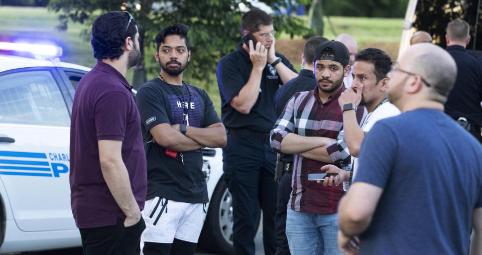 People gather across from the campus of UNC Charlotte after a fatal shooting at the school, Tuesday, April 30, 2019, in Charlotte, N.C. (AP Photo/Jason E. Miczek)