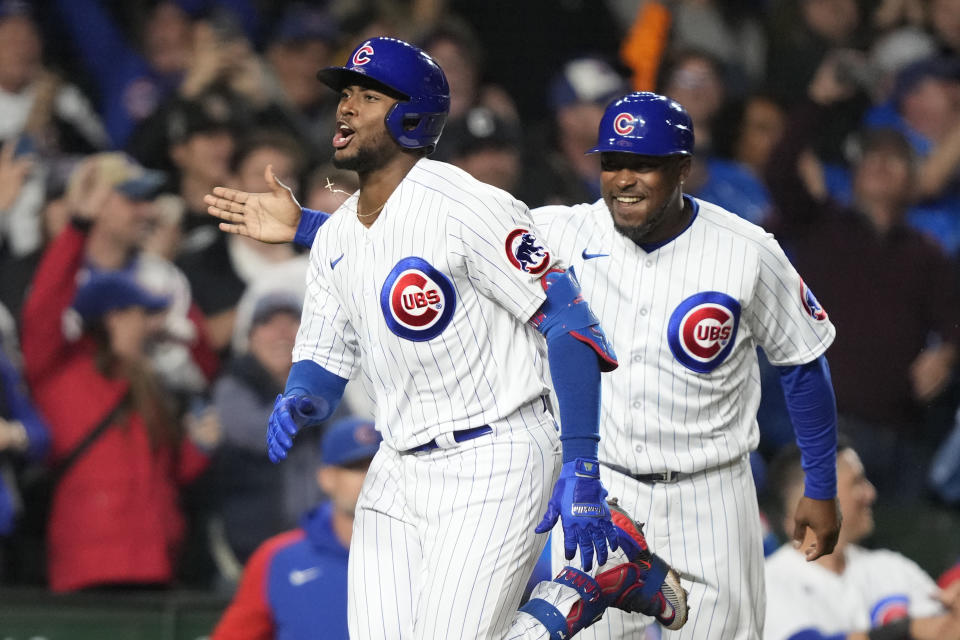 Chicago Cubs third base coach Willie Harris, right, smiles after Alexander Canario home after Canario's grand slam off Pittsburgh Pirates relief pitcher Kyle Nicolas during the eighth inning of a baseball game Tuesday, Sept. 19, 2023, in Chicago. (AP Photo/Charles Rex Arbogast)