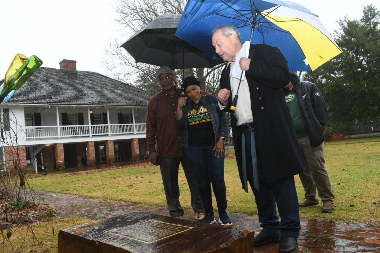 Local historian Michael Wynne (front right) reads the inscription of the enslaved people's memorial at Kent Plantation House to Leslie and Shelia Draper of Simmsport. Wynne led them through Kent House’s Black History Month tour, “The Enslaved Experience in Cenla: Living in Bondage.”