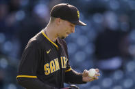 San Diego Padres starting pitcher Blake Snell studies a new ball after giving up a two-run home run to Colorado Rockies' Josh Fuentes during the second inning of the second game of a baseball doubleheader Wednesday, May 12, 2021, in Denver. (AP Photo/David Zalubowski)