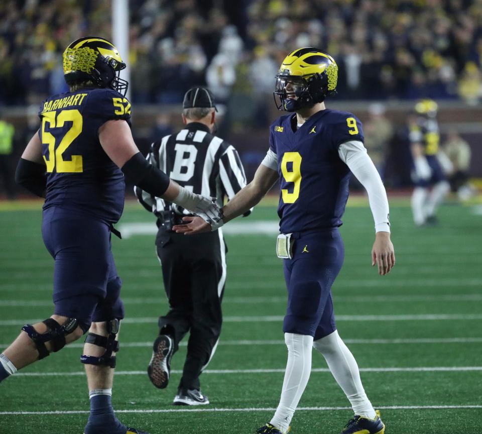 Michigan quarterback J.J. McCarthy shakes hands with offensive lineman Karsen Barnhart after a score against Purdue during the second half of Michigan's 41-13 win on Saturday, Nov 4, 2023, in Ann Arbor.