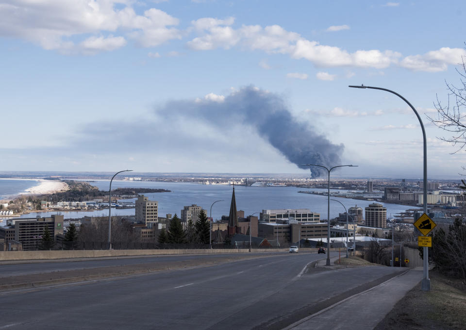 A fire at&nbsp;the Husky Oil Refinery in Superior, Wisconsin, is seen in the distance on April 26. Mitchell toured the site on a visit to the city. (Photo: Stephen Maturen via Getty Images)