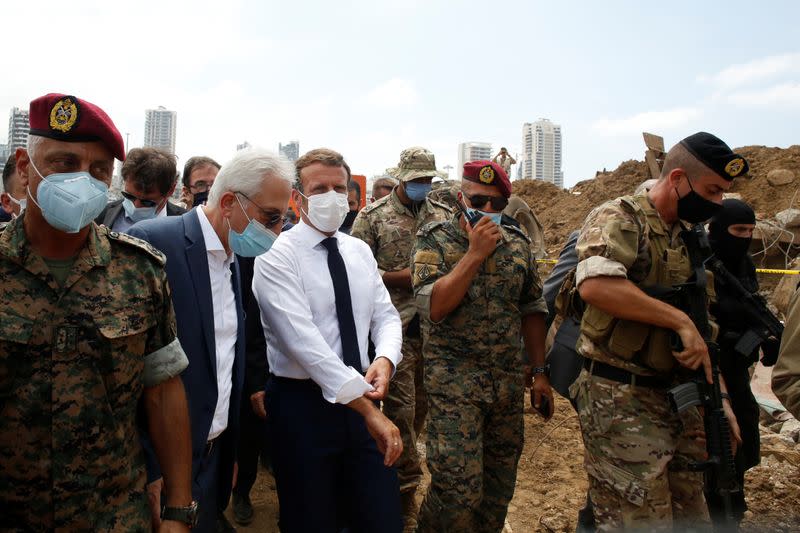 French President Emmanuel Macron gestures as he visits the devastated site of the explosion at the port of Beirut