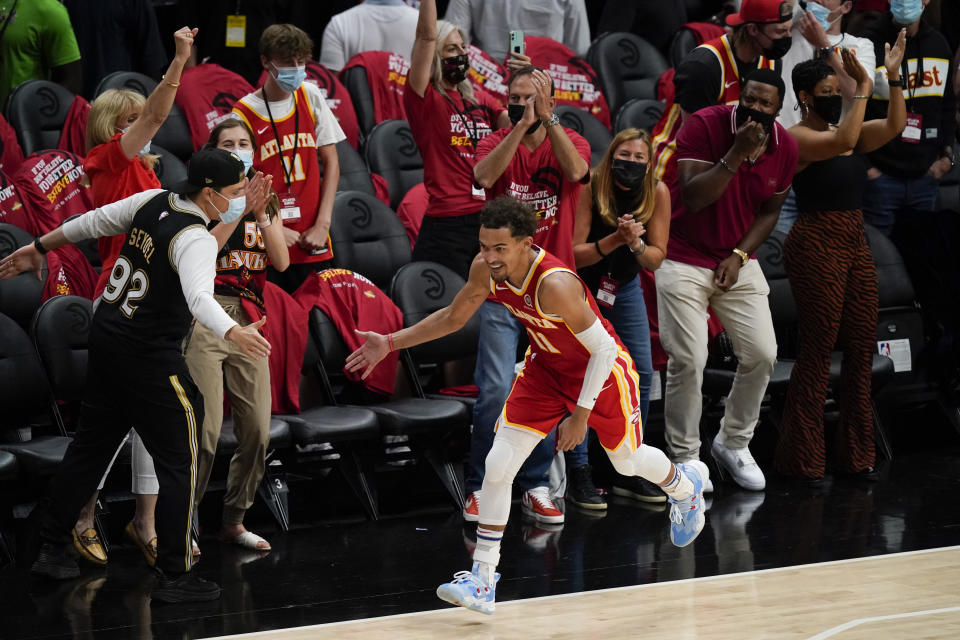 Atlanta Hawks' Trae Young (11) high-fives a fan after scoring a 3-pointer during the second half of Game 3 of the NBA Eastern Conference basketball finals against the Milwaukee Bucks, Sunday, June 27, 2021, in Atlanta. (AP Photo/Brynn Anderson)