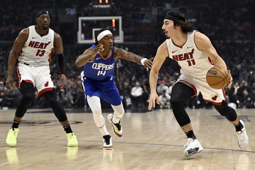 Miami Heat guard Jaime Jaquez Jr. (11) drives past Los Angeles Clippers guard Terance Mann (14) during the first half of an NBA basketball game, Monday, Jan. 1, 2024 in Los Angeles. (AP Photo/Alex Gallardo)