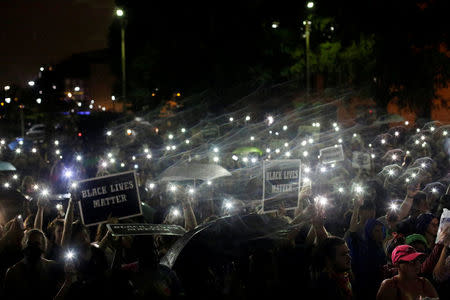 Demonstrators hold up their mobile phones as they continue to protest for a fourth day after the not guilty verdict in the murder trial of Jason Stockley, a former St. Louis police officer, charged with the 2011 shooting of Anthony Lamar Smith, who was black, in St. Louis, Missouri, U.S., September 18, 2017. REUTERS/Joshua Lott