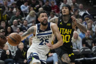 Minnesota Timberwolves guard Austin Rivers (25) drives around Utah Jazz guard Jordan Clarkson (00) during the first half of an NBA basketball game Friday, Dec. 9, 2022, in Salt Lake City. (AP Photo/Rick Bowmer)