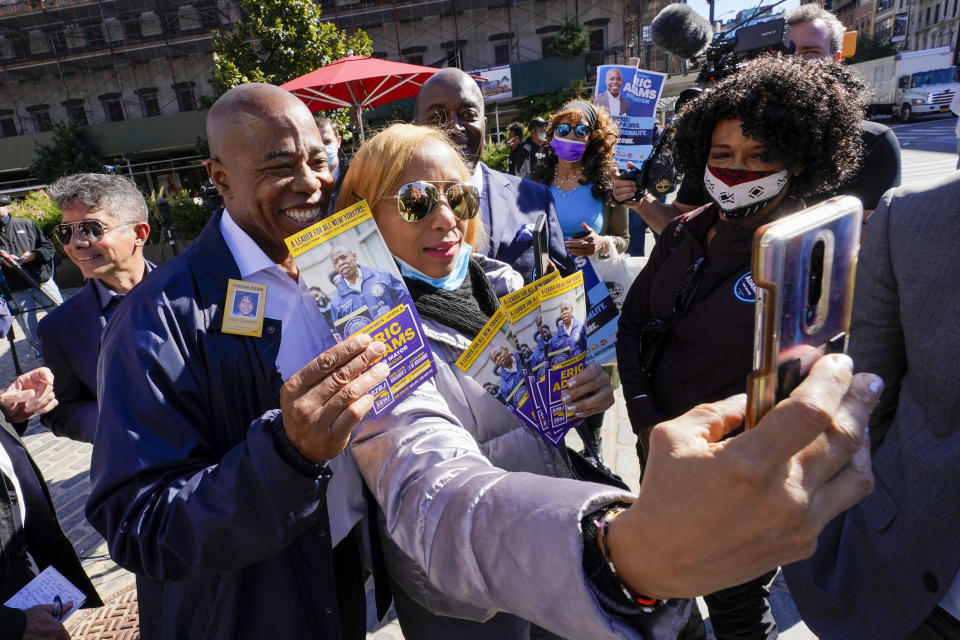 Eric Adams, left, the Democrat candidate for New York Mayor, poses for a photo with a supporter during a campaign event, Tuesday, Oct. 19, 2021, in New York. (AP Photo/Mary Altaffer)