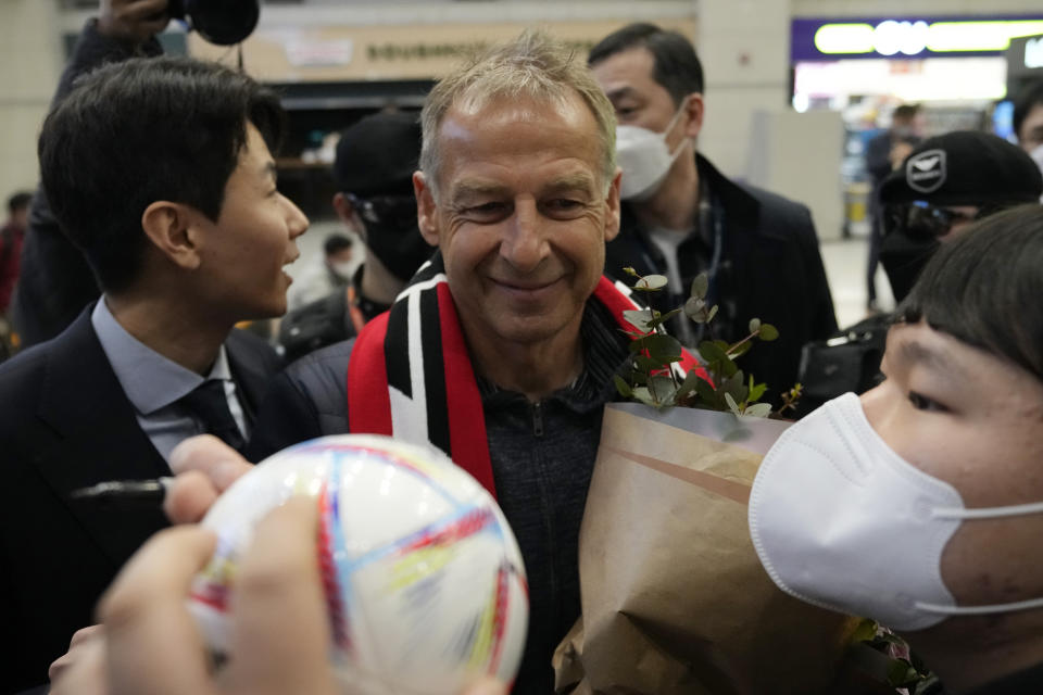 South Korea's new national soccer team head coach Jurgen Klinsmann is greeted by a fan upon his arrival at the Incheon International Airport in Incheron, South Korea, Wednesday, March 8, 2023. Klinsmann, who won the World Cup as a player with West Germany in 1990, replaces Paulo Bento. The Portuguese coach left the team after leading South Korea to the second round at last year's World Cup in Qatar. (AP Photo/Ahn Young-joon)