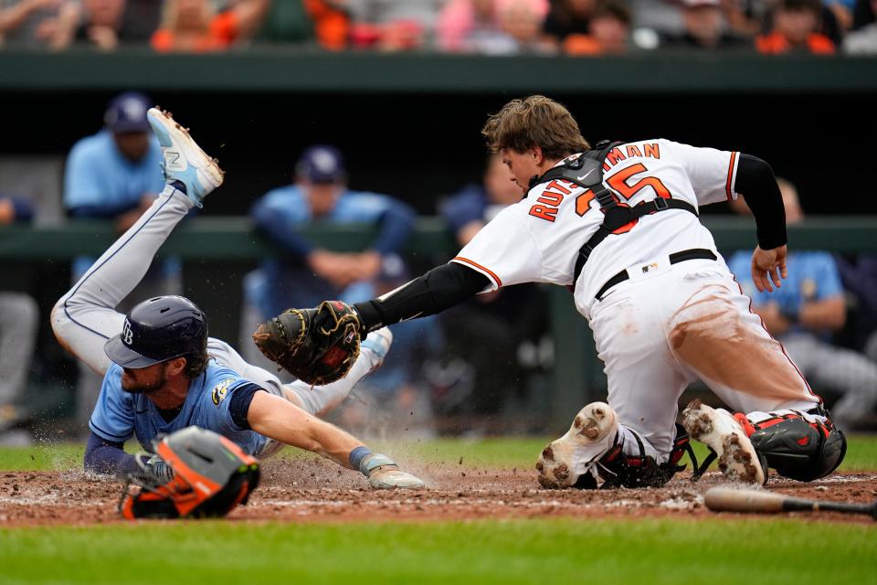 Baltimore Orioles catcher Adley Rutschman (35) tags out Tampa Bay Rays' Josh Lowe in the ninth inning of a baseball game, Sunday, Sept. 17, 2023, in Baltimore. The Orioles won 5-4 in 11 innings to clinch a playoff spot. (AP Photo/Julio Cortez)