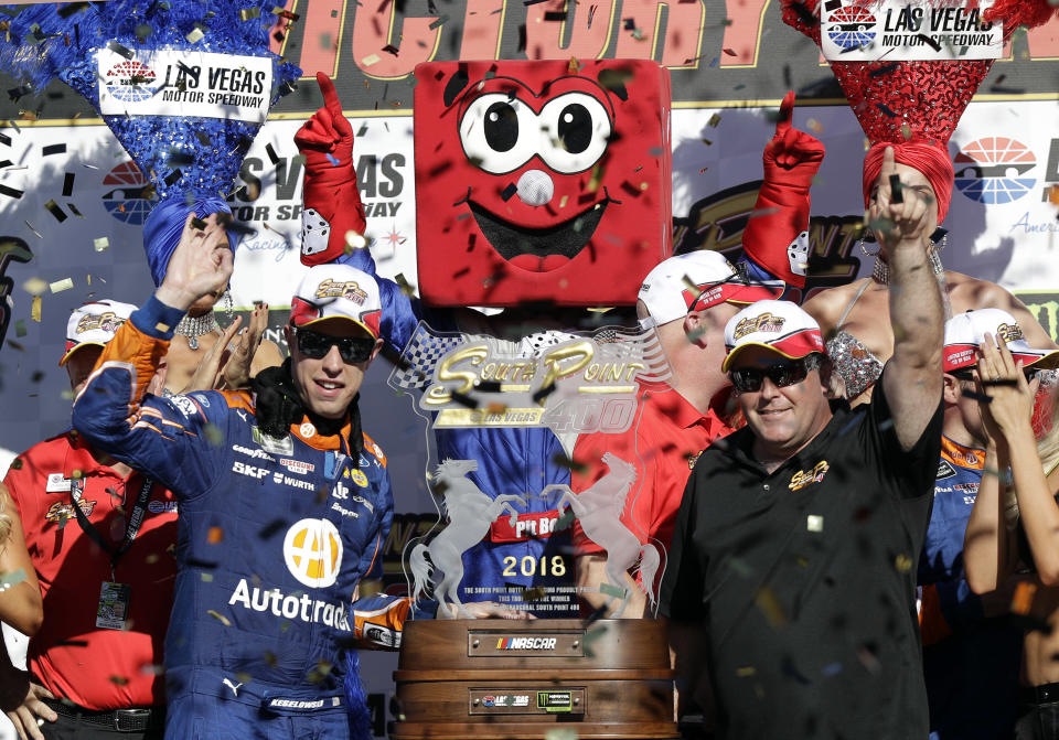 Brendon Gaughan, right, presents Brad Keselowski with a trophy following a NASCAR Cup Series auto race Sunday, Sept. 16, 2018, in Las Vegas. (AP Photo/Isaac Brekken)