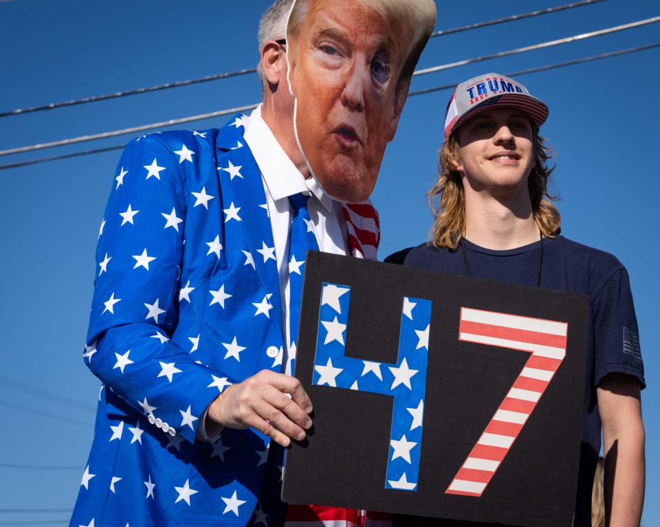 Ian Wollard, a rally volunteer from Waco, poses for a photo with a man dressed as the former president Saturday morning. The event was Trump's first public rally of the 2024 election cycle.
