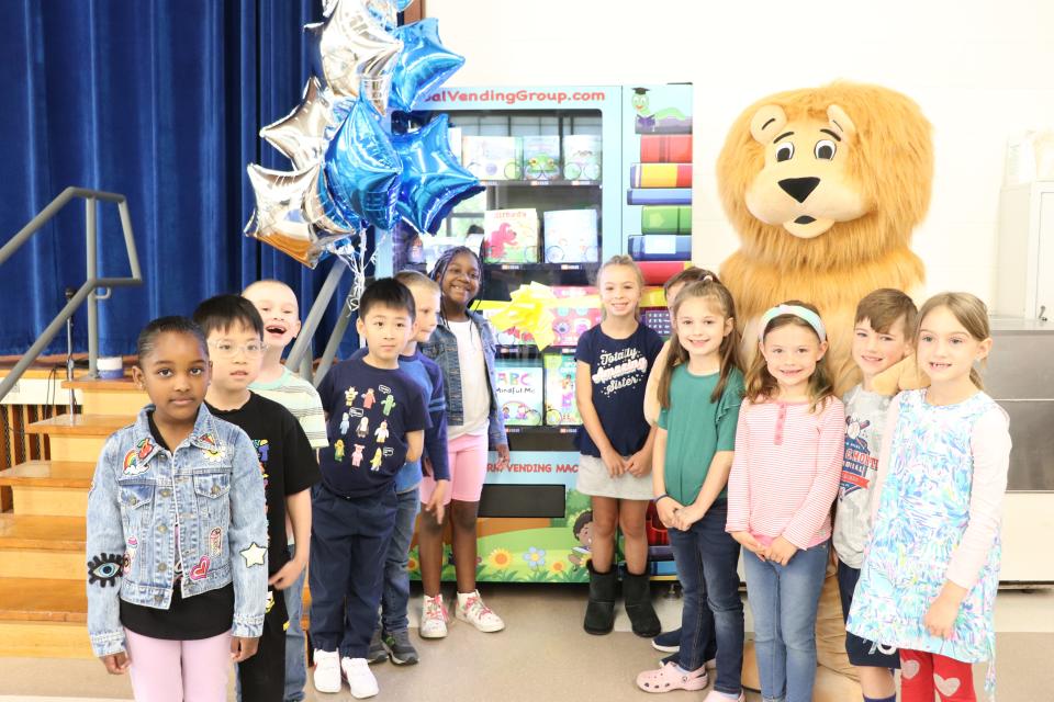 Merrill Elementary School in Raynham unveils its new Inchy the Bookworm vending machine, with a little help from Merrill the Lion, the school's mascot on Thursday morning, May 27, 2022.