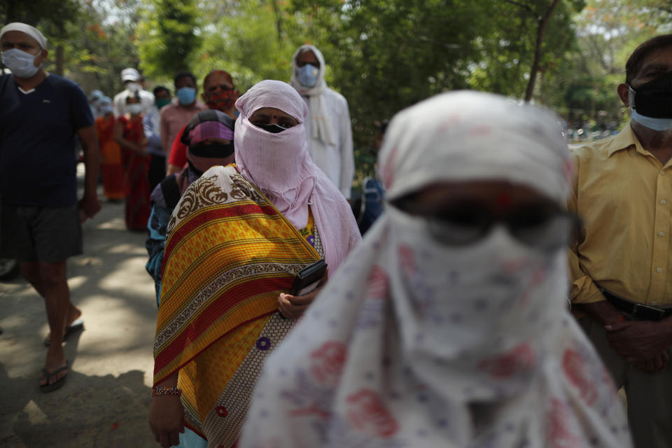 Indians cover their faces as a precaution against the coronavirus line up to receive the vaccine for COVID-19 at a medical college in Prayagraj, India, Saturday, May 8, 2021. Two southern states in India became the latest to declare lockdowns, as coronavirus cases surge at breakneck speed across the country and pressure mounts on Prime Minister Narendra Modi's government to implement a nationwide shutdown. (AP Photo/Rajesh Kumar Singh)