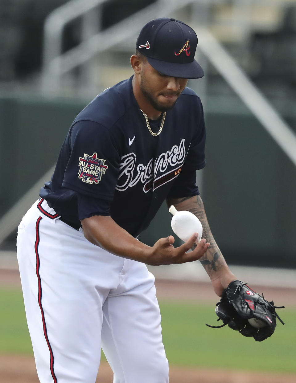 Atlanta Braves pitcher Huascar Ynoa powders his throwing hand with a rosin bag while throwing live batting practice during baseball spring training, Wednesday, Feb. 24, 2021, in North Port, Fla. (Curtis Compton/Atlanta Journal-Constitution via AP)