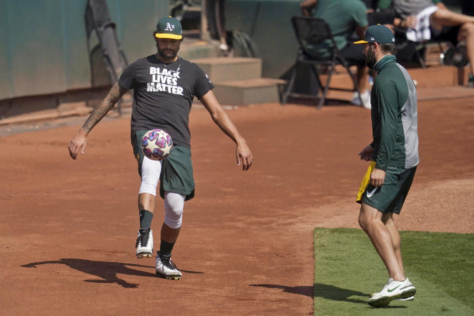 Oakland Athletics' Sean Manaea, left, and Lou Trivino kick a soccer ball during a baseball workout in Oakland, Calif., Monday, Sept. 28, 2020. The Athletics are scheduled to play the Chicago White Sox in an American League wild-card playoff series starting Tuesday. (AP Photo/Jeff Chiu)