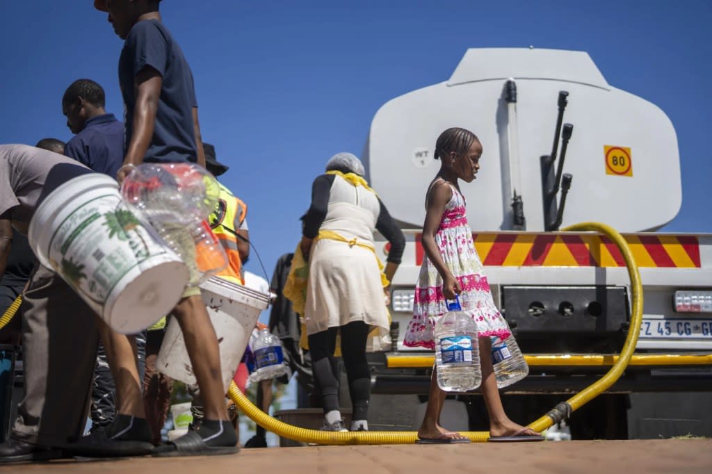 Residents of the township of Soweto, South Africa, queue for water Saturday, March 16, 2024. (AP Photo/Jerome Delay)