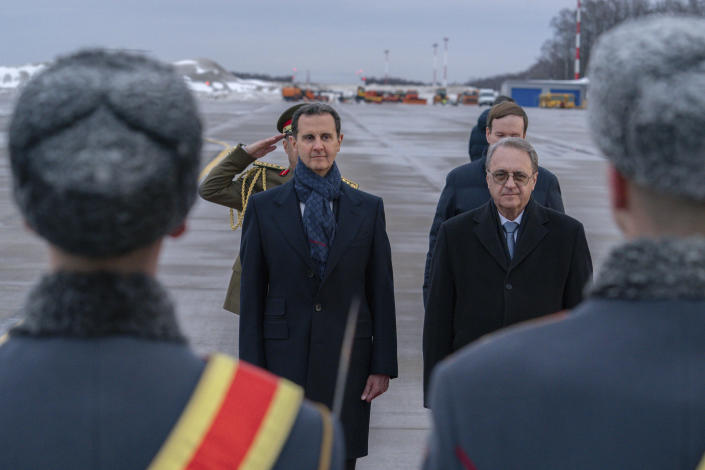 In this photo released by the Syrian official news agency SANA, visiting Syrian President Bashar Assad, left, and Mikhail Bogdanov, right, Deputy Minister of Foreign Affairs of Russia and Special Representative of the President of Russia for the Middle East, review an honor guard during a welcome ceremony upon Assad's arrival at Vnukovo airport in Moscow, Russia, Tuesday, March 14, 2023. Assad landed in Russia Tuesday where he is scheduled to meet top ally President Vladimir Putin. (SANA via AP)