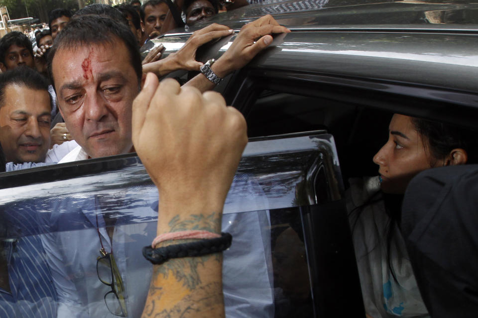 Bollywood star Sanjay Dutt, second left, arrives with wife Manyata, right, to surrender before a court in Mumbai, India, Thursday, May 16, 2013. Dutt has been sentenced to five years in prison for a 1993 weapons conviction linked to a deadly terror attack in Mumbai that killed 257 people. The 53-year-old actor served 18 months in jail before being released on bail in 2007 pending an appeal. The Supreme Court reduced his prison sentence to five years from the six-year term initially handed down. (AP Photo/Rajanish Kakade)