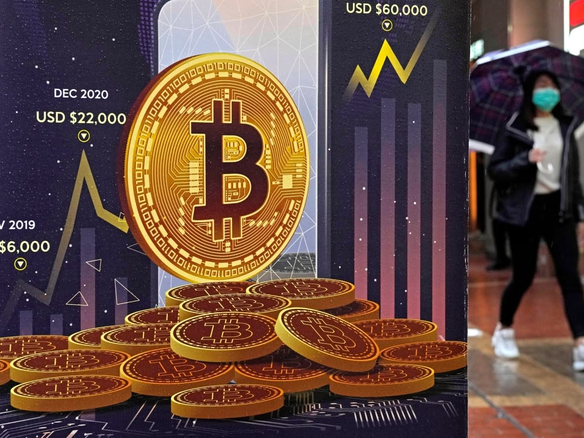 An advertisement for the cryptocurrency bitcoin is displayed on a street in Hong Kong in this file photo from February. The value of the cryptocurrency has plummeted since December 2021, when the price of bitcoin was around $47,000 US. On Dec. 27, the price of bitcoin was hovering around $17,000 US. (Kin Cheung/The Associated Press - image credit)